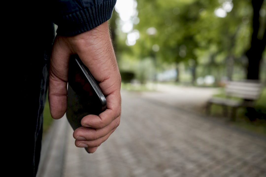 Person holding smartphone near police station
