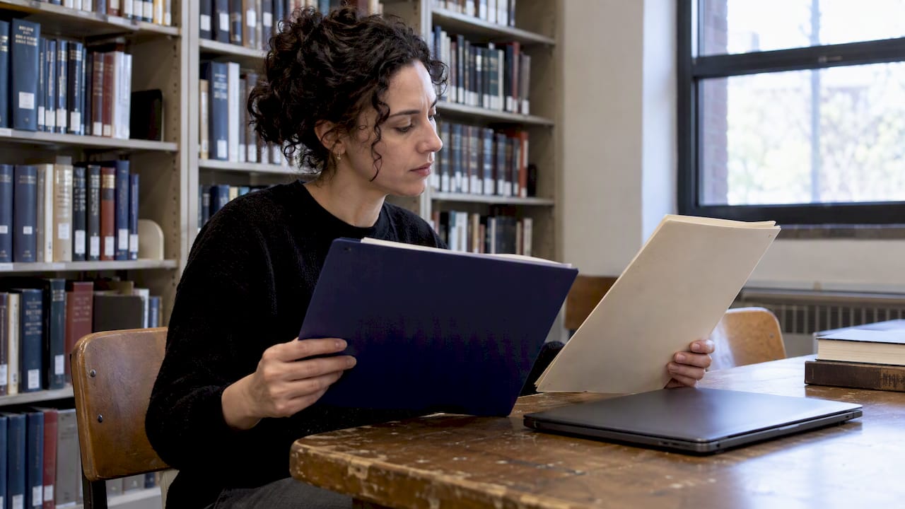 Researcher comparing cold case source folders